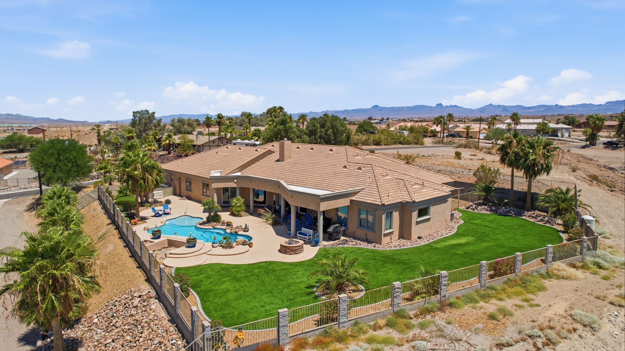 Aerial real estate photo of a desert home with a pool and landscaped yard